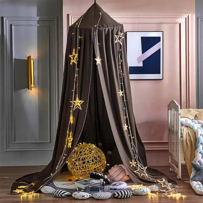 Children's room with a dark curtain canopy, star lights, and toys on the floor.
